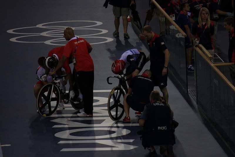 Coaches steadying their riders at the start line of the London 2012 velodrome